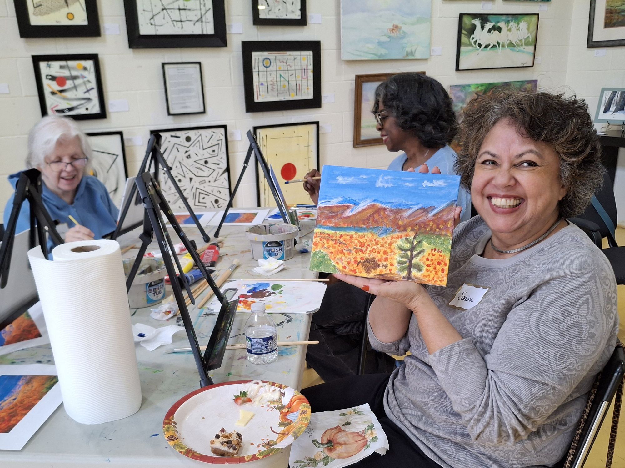 Five older women smiling and making collages